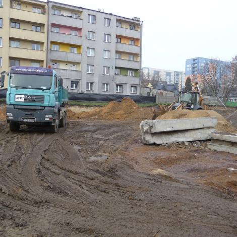  Listopad 2019, samochód ciężarowy do wywozu odpadów oraz koparka, w tle blok mieszkalny