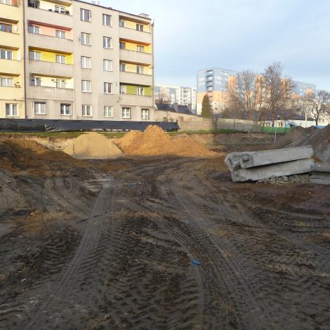 pusty plac budowy, w tle blok mieszkalny