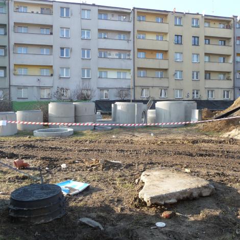 Grudzień 2019, kręgi betonowe leżące na placu na tle bloku mieszkalnego