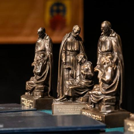 Trzy statuetki z brązu przedstawiające św. Kamila z chorym