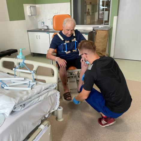 Rehabilitant zajmuje się pacjentem siedzącym na wózku