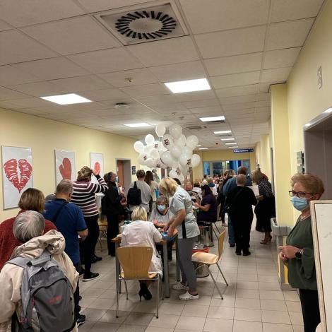 pacjenci przy stolikach i pod gabinetami