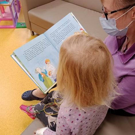 opiekunka czytająca małej dziewczynce