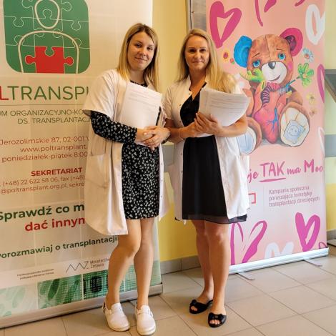 Rejestratorki przy wejściu do poradni z ankietami dla pacjentów 