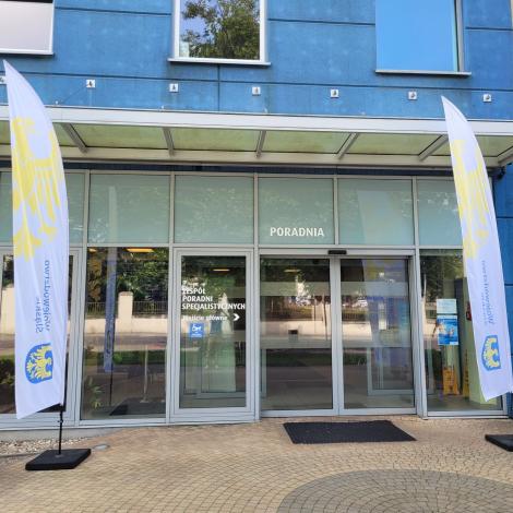 Wejście do poradni SCCS oraz flagi Urzędu Marszałkowskiego