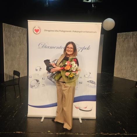 P. Urszula Goebel z kwiatami i wyróżnieniem