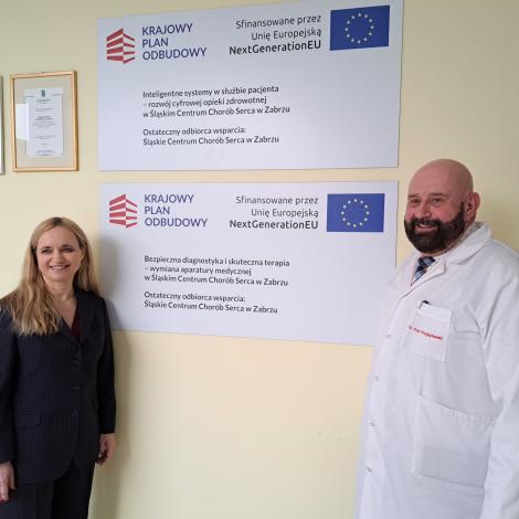 Minister Zdrowia oraz dyrektor SCCS obok tablic dot. finasowania projektów z KPO