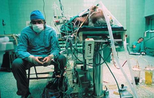  Sala operacyjna tuż po kilkunastogodzinnej operacji przeszczepu serca. Tuż obok pacjenta siedzi profesor Religa. W tle widać wyczerpanego i śpiącego ze zmęczenia asystenta Religii. 